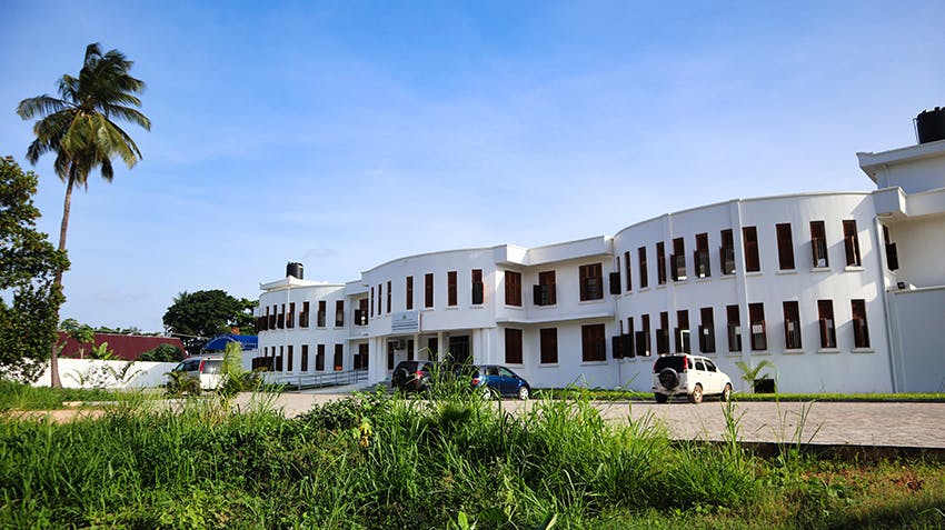A large white building with grass out the front
