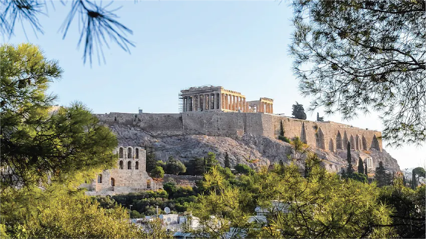 A beautiful view of the Acropolis of Athens, rising above the city, featuring the Parthenon, the Propylaea, and the Erechtheion.