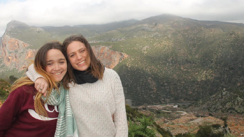 Two female students smiling and posing in Morocco, with mountains in the background, Intern Abroad HQ