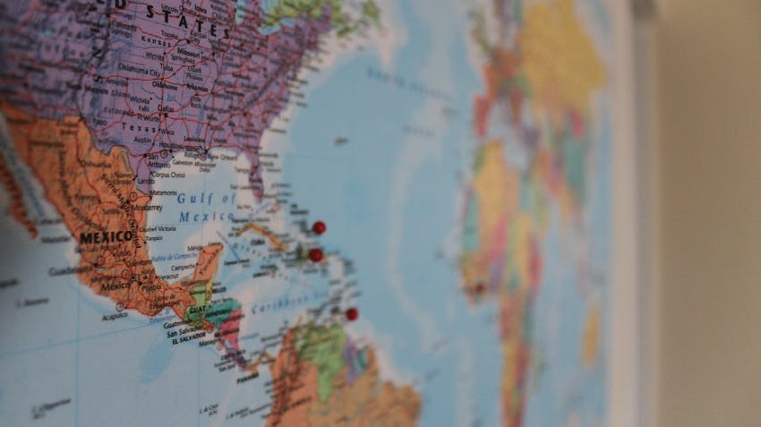 A photo of a world map with pins in it, to mark destinations