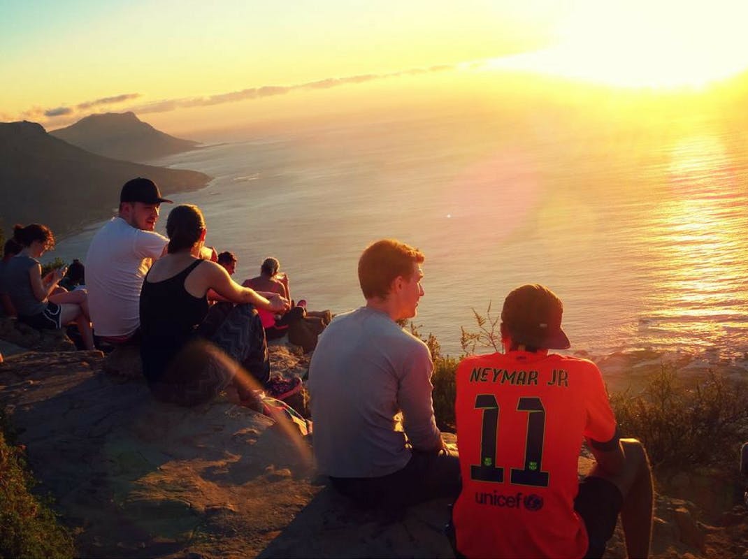 Internship students watch the sun set on Lions Head Cape Town