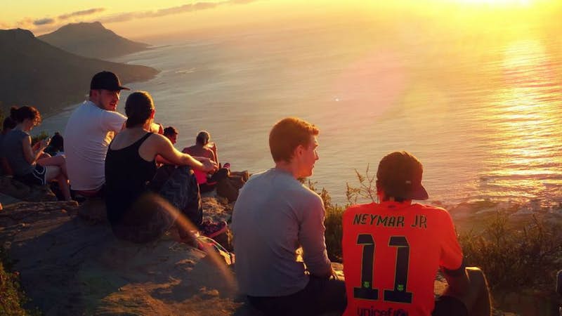 Internship students watch the sun set on Lions Head Cape Town