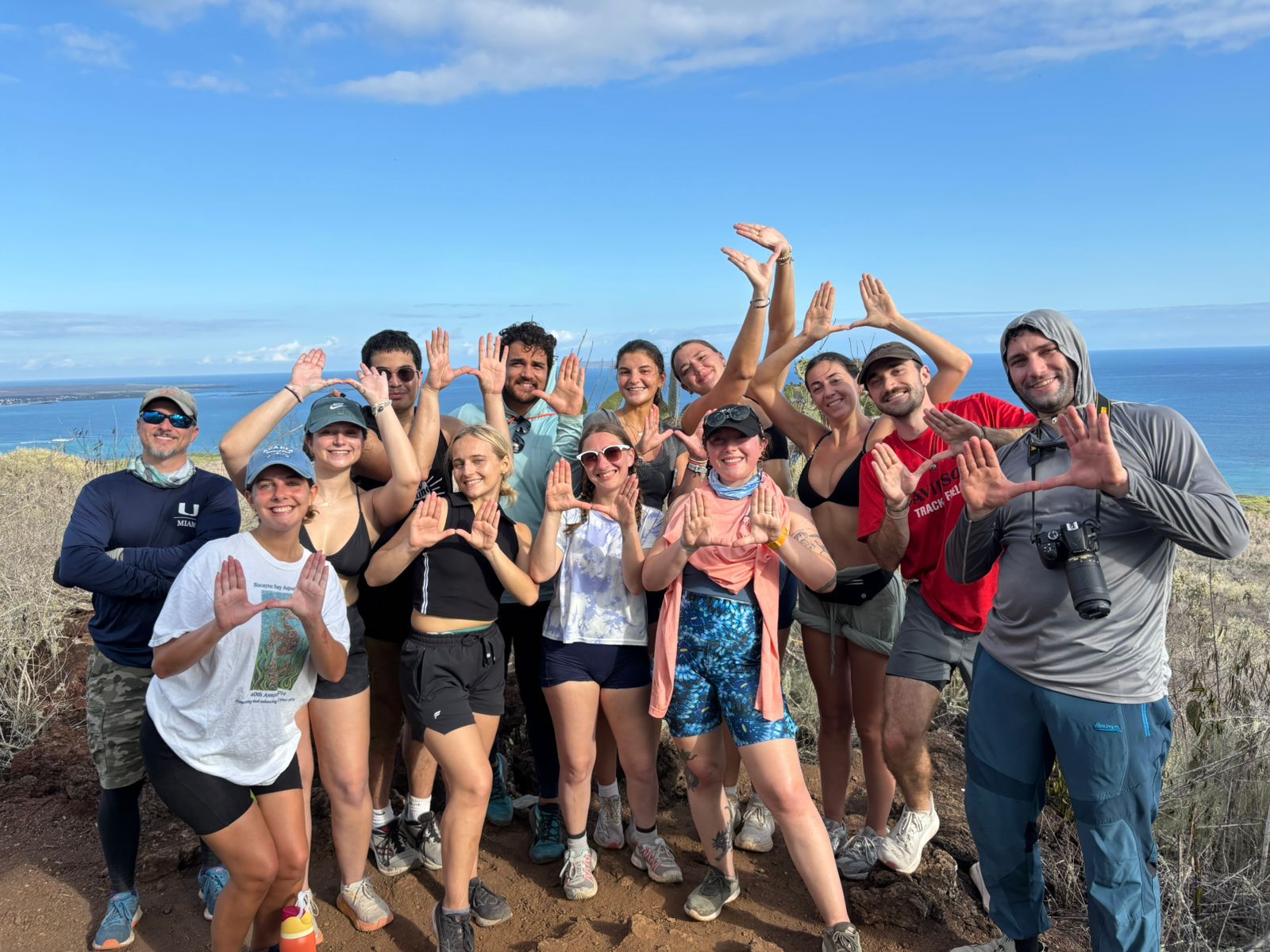 A happy group of students in the Galapagos, posting in front of the sea