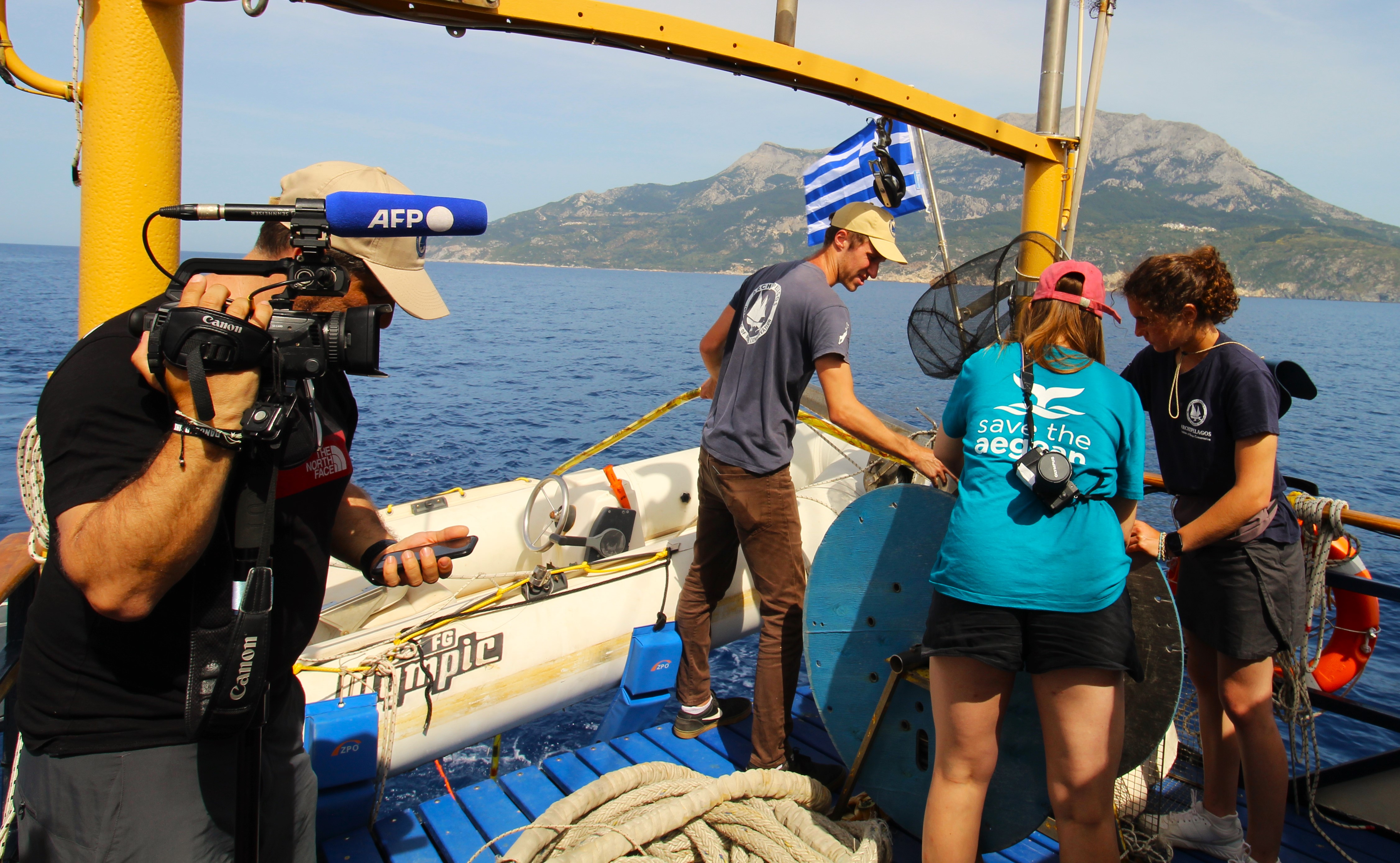 Marine Conservation Research Expedition onboard the vessel and filming, with Greek flag shown
