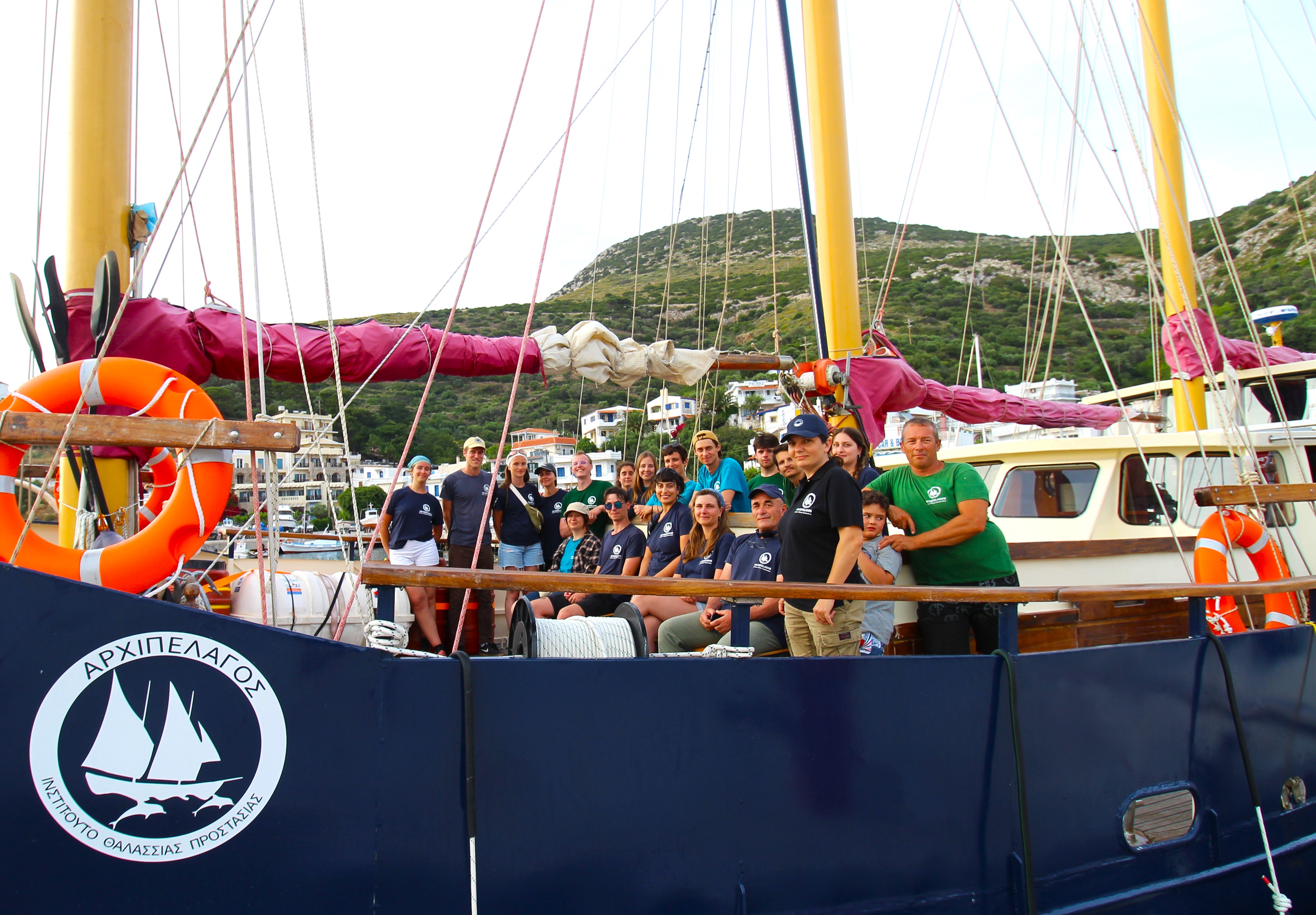 Marine Conservation Research Expedition group poses on the boat within the marina