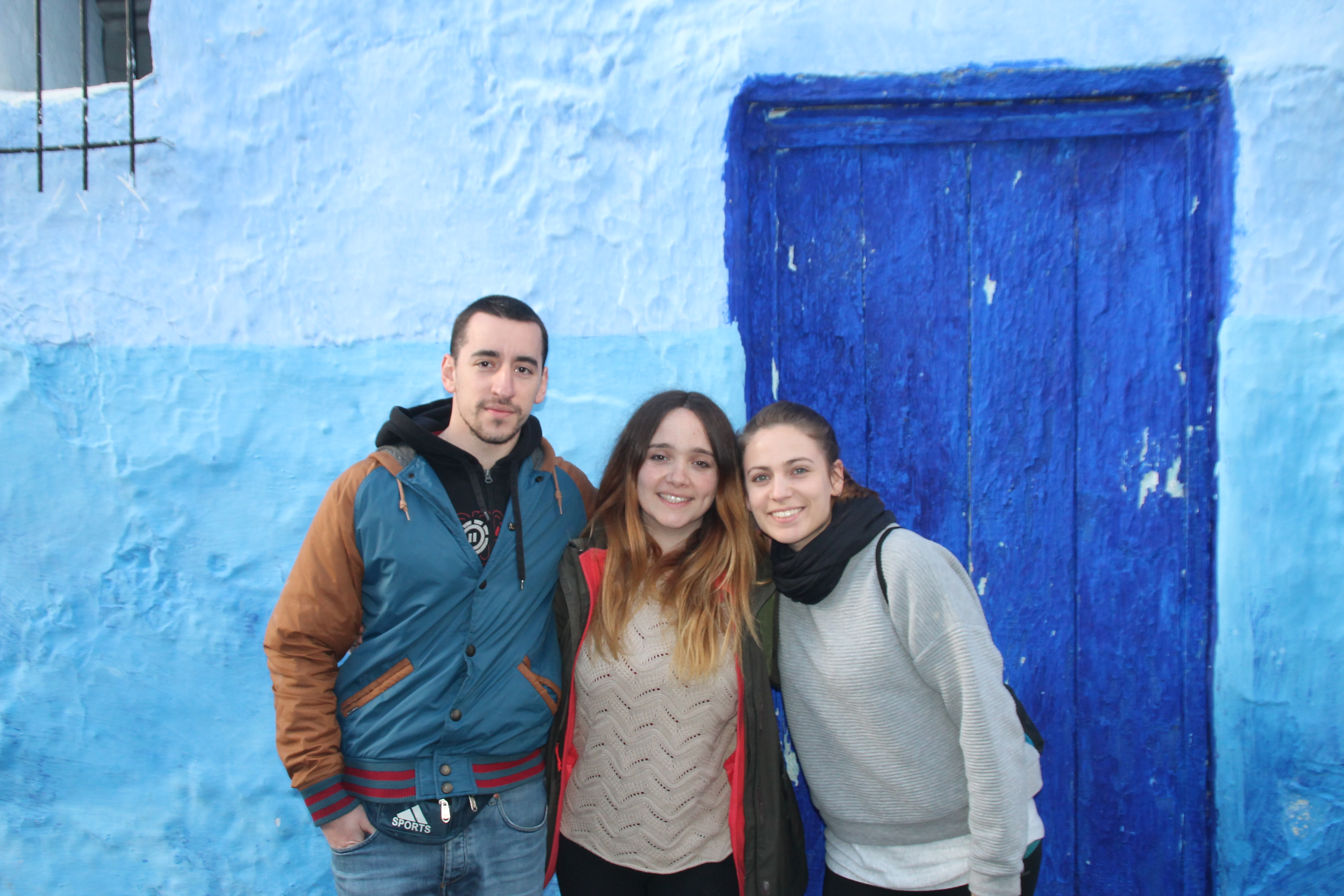 Students standing against a blue building backdrop in Morocco