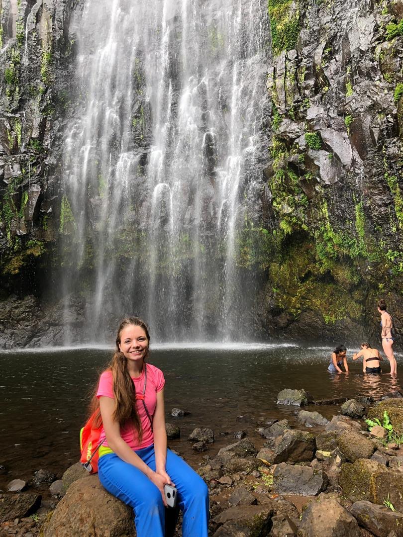 Intern in Africa, relaxes next to a waterfall, with Intern Abroad HQ