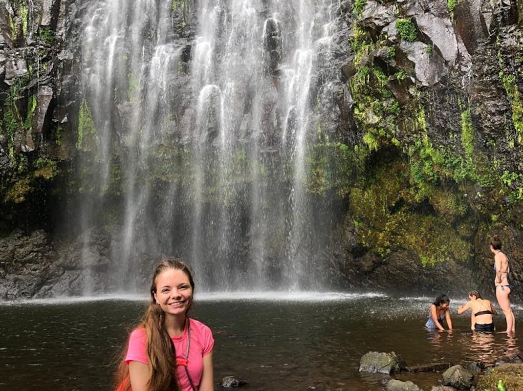Intern in Africa, relaxes next to a waterfall, with Intern Abroad HQ