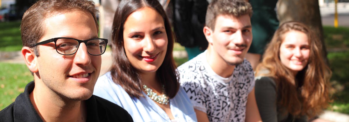 Intern Abroad HQ coordinators in Italy sitting together in a sunny park during a casual team moment.
