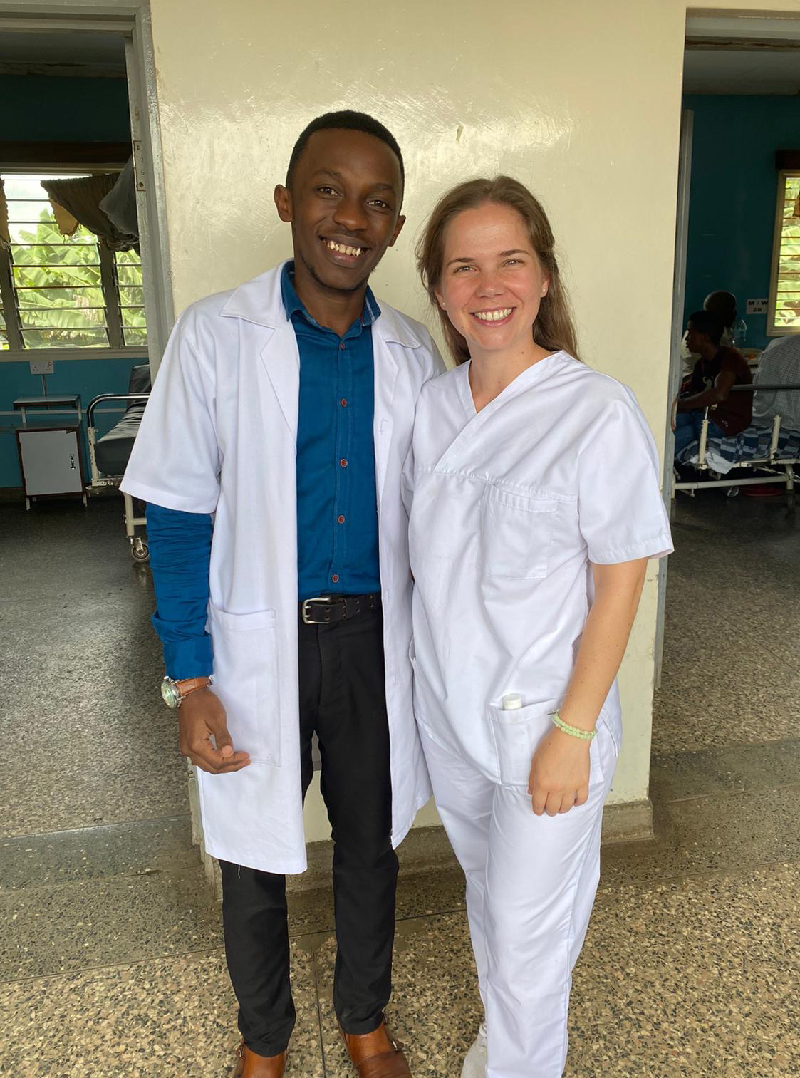 Two smiling medical interns pose in scrubs inside a hospital during a clinical internship abroad.